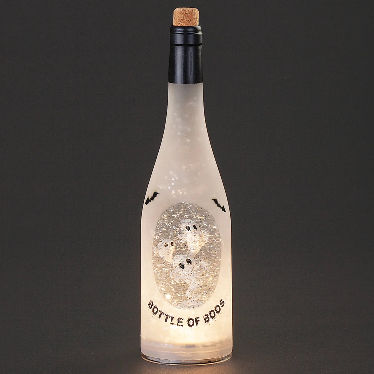 A frosted glass bottle with a cork stopper, illuminated from within to show a glittery ghost design and the words 'BOTTLE OF BOOS' on a dark gray background.
