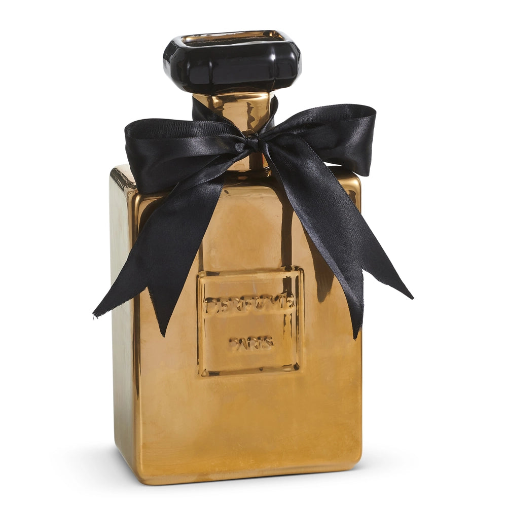 A gold perfume bottle vase with a black cap and a large black satin bow tied around the neck, shown on a white background.