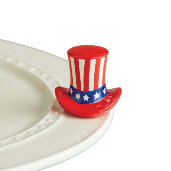 A nora fleming miniature figurine of a hat with a patriotic red, white, and blue design