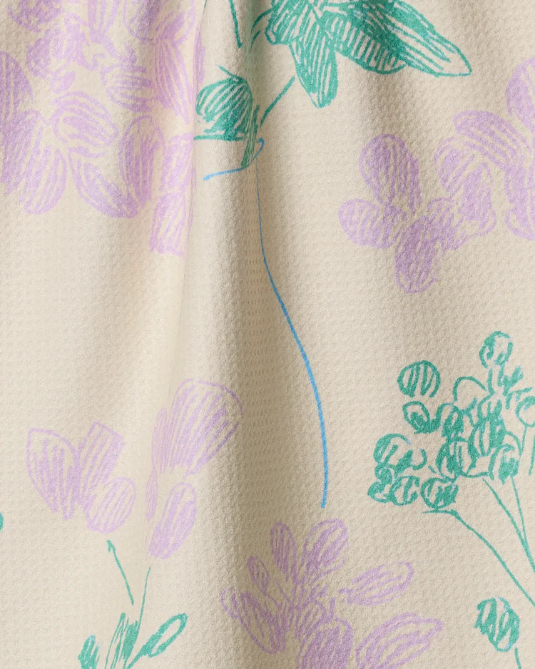 Geometry Julieta Close-up of fabric with floral pattern in purple and green on beige background