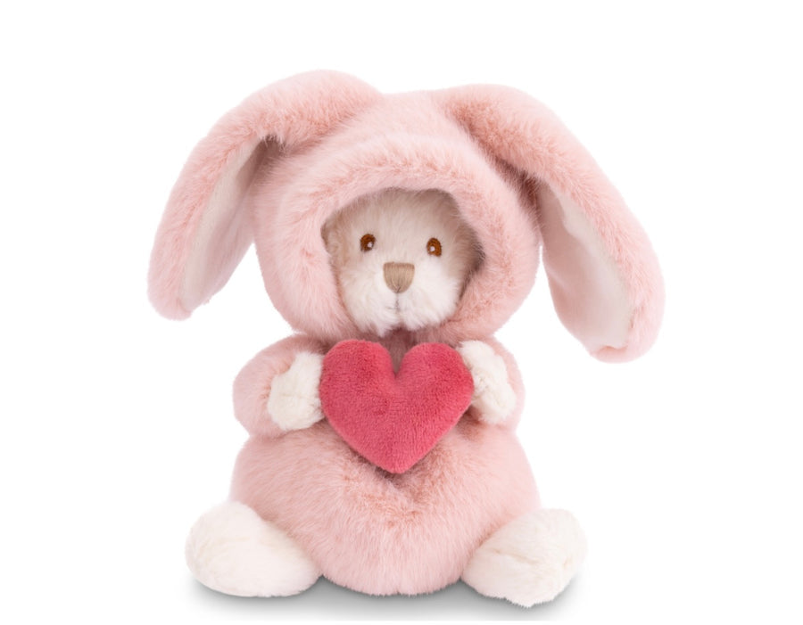 A plush stuffed bunny doll wearing a soft pink hooded outfit and holding a pink heart, photographed on a clean white background.