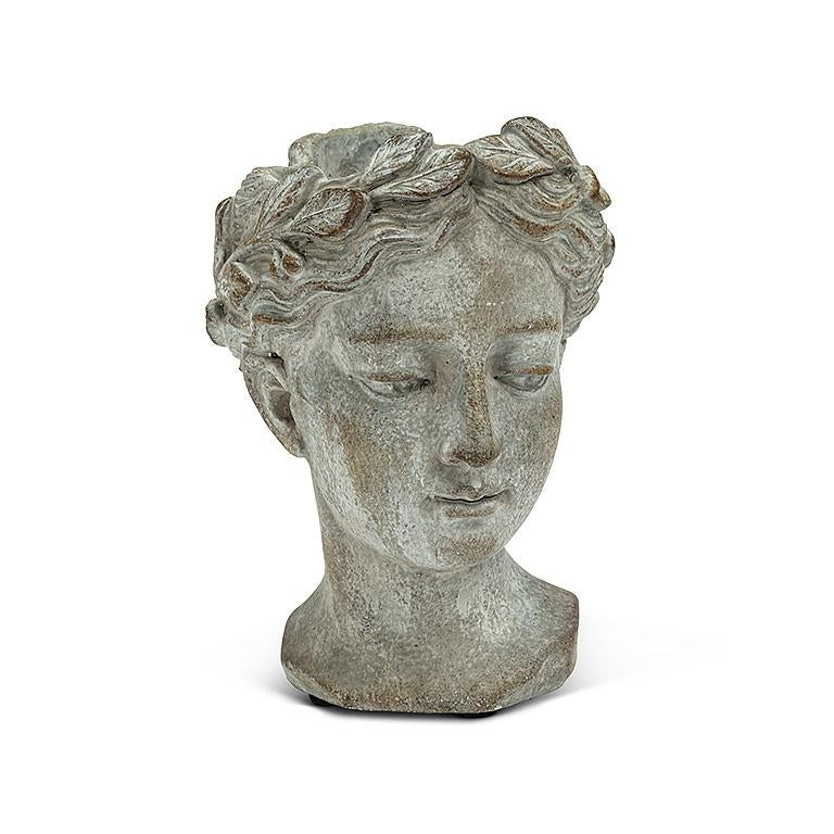 A gray concrete planter in the shape of a woman's head with detailed hair and facial features.