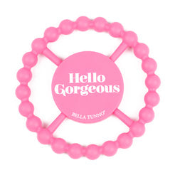 A pink silicone teether with the text 'Hello Gorgeous' on it.