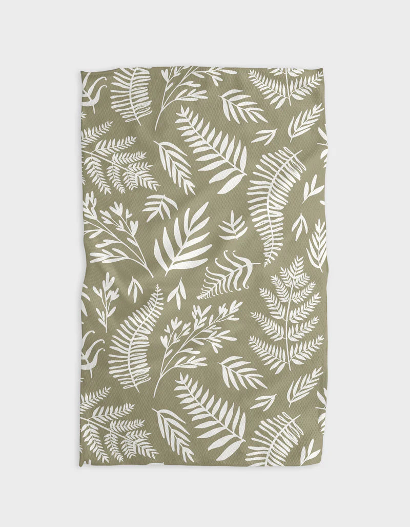 A green tea towel with a white leaf pattern displayed flat.