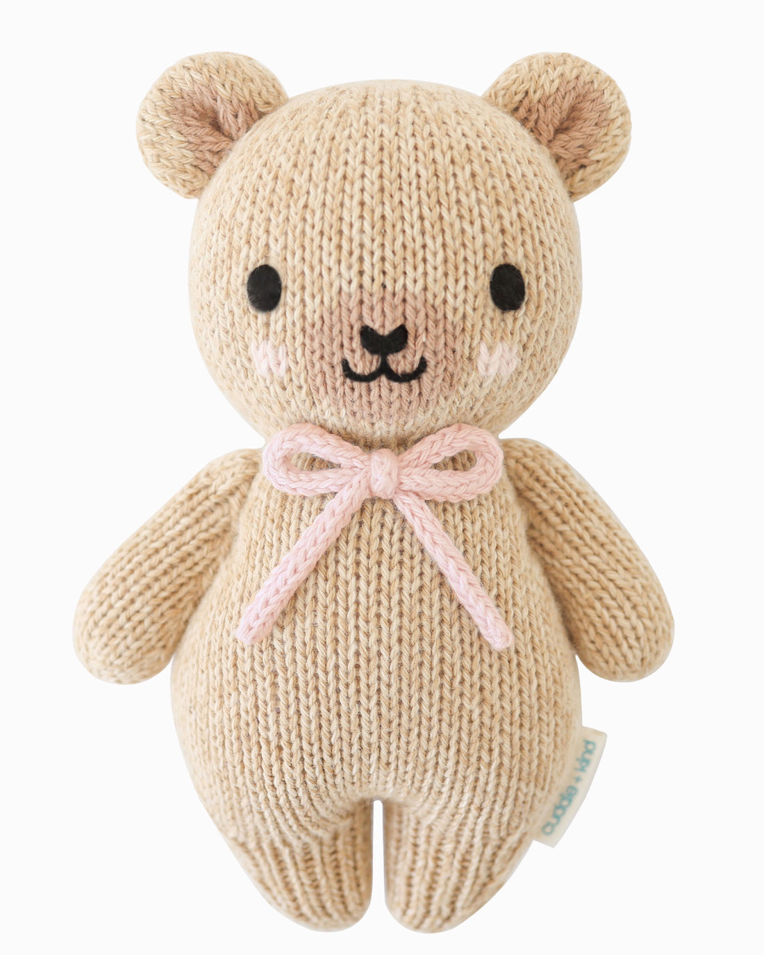 Knitted teddy bear with a pink bow on a white background