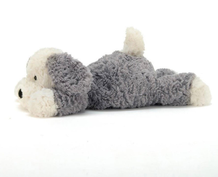 A plush dog toy lying on its side, made of soft gray and white textured fabric with small black eyes and nose, photographed on a plain white background.
