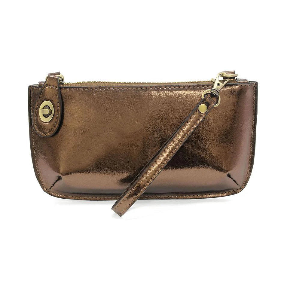 A metallic copper mini crossbody wristlet clutch with brass plated hardware and a removable wrist strap.