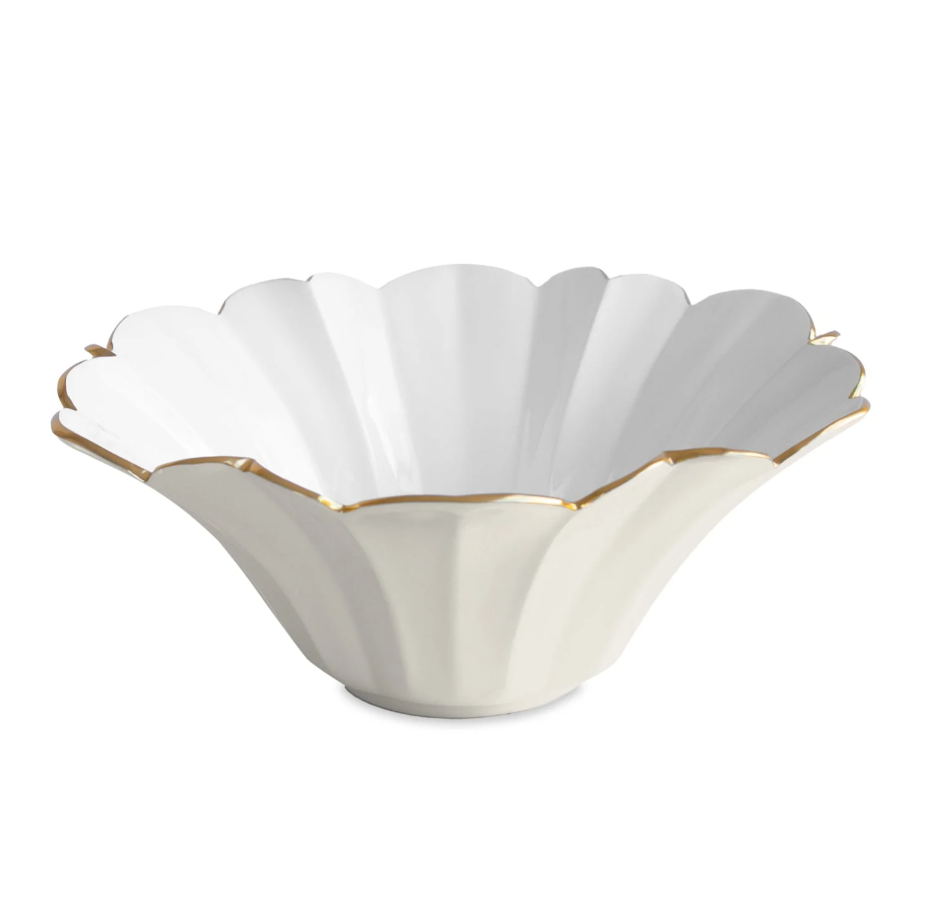 Decorative white bowl with scalloped edge and gold trim on a white background