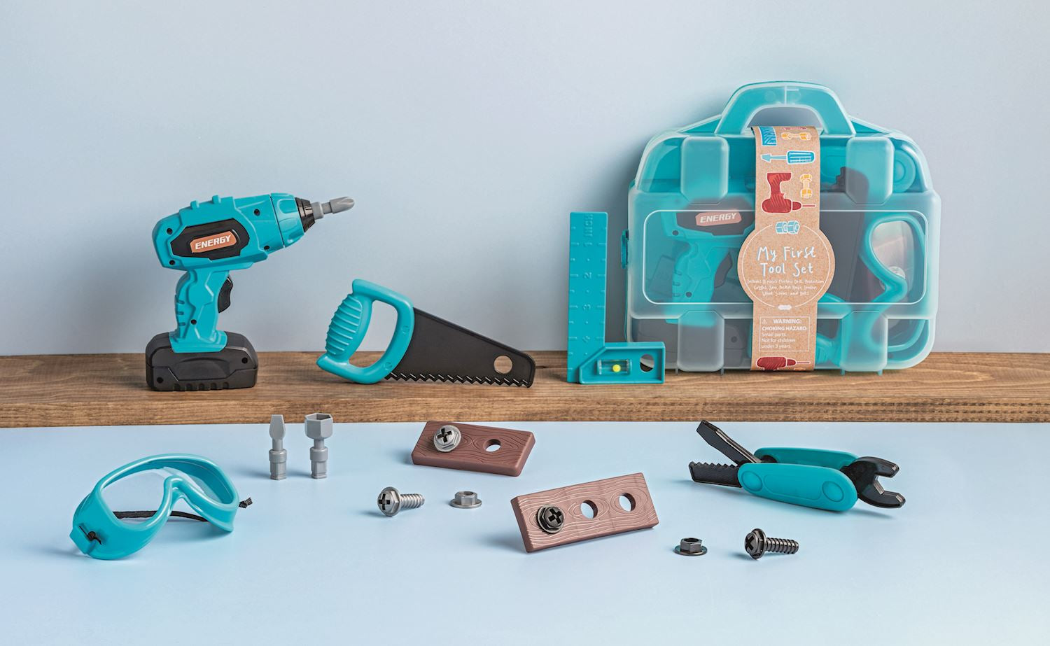 Set of tools including a drill, saw, and goggles on a light blue background