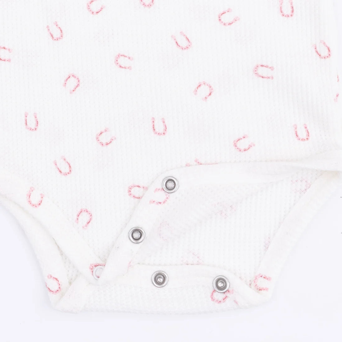 White Angel Dear Little Horseshoes bodysuit with long sleeves and a snap bottom with a print of pink  little horseshoes showing an upclose image of the snaps
