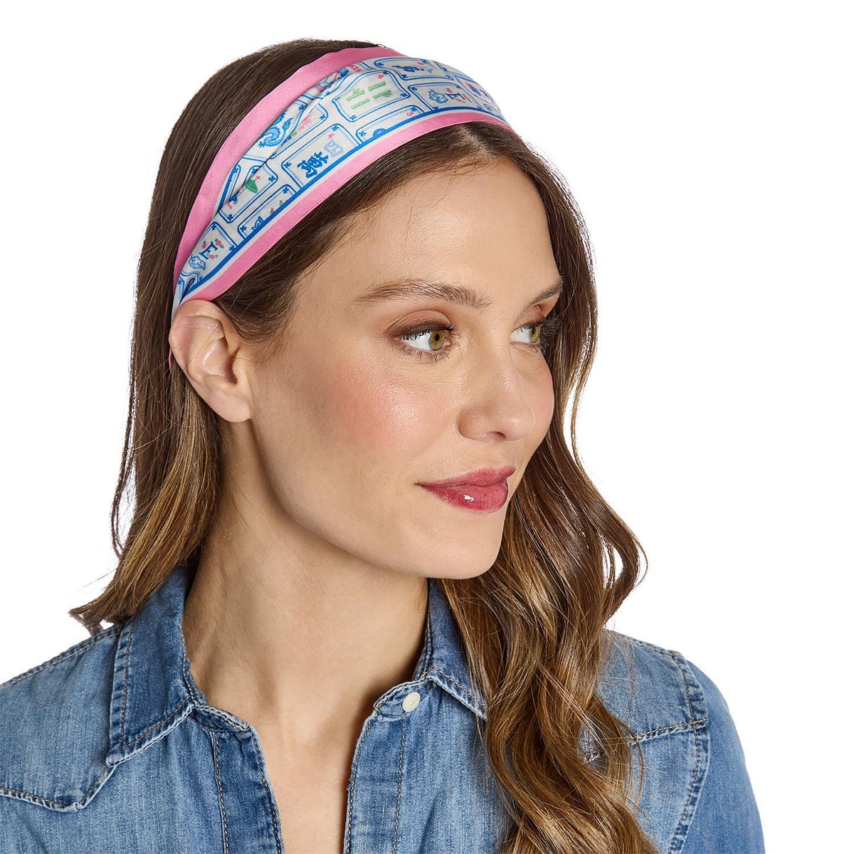 Woman wearing a skinny scarf with a blue and pink mahjong pattern on a white background