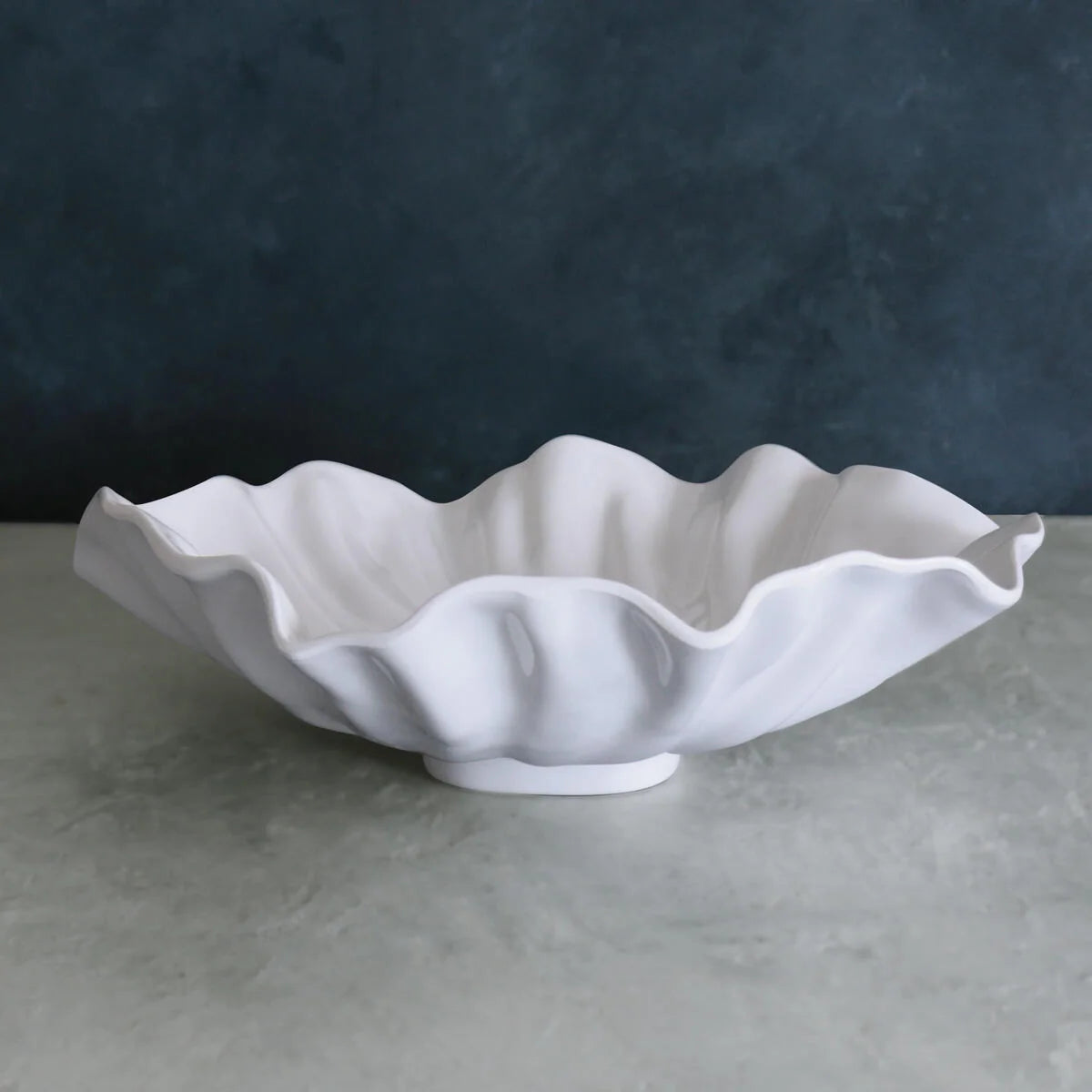 White luxury melamine bowl with wavy edge on a gray surface 