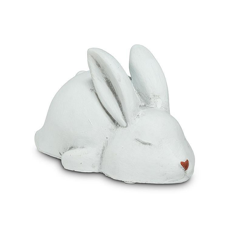 White sleeping rabbit made of cement with a heart nose