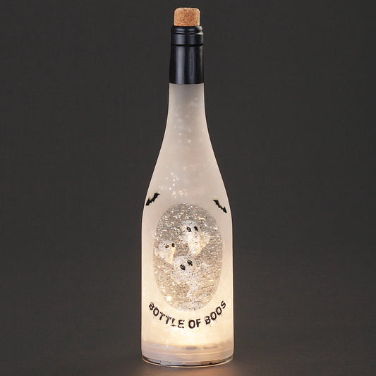 A frosted glass bottle with a cork stopper, illuminated from within to show a glittery ghost design and the words 'BOTTLE OF BOOS' on a dark gray background.