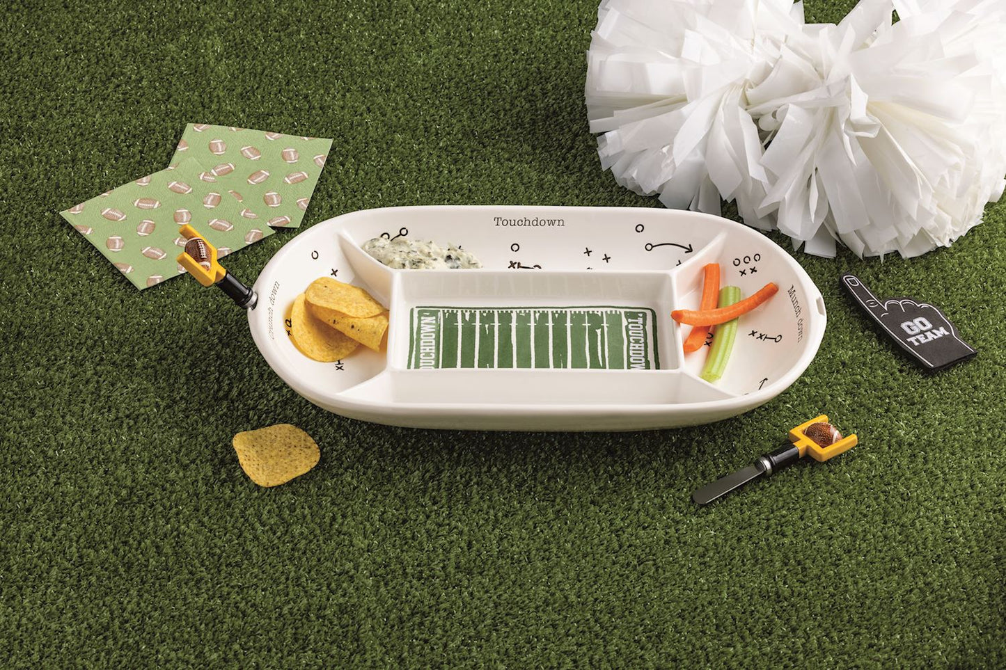 Football-themed snack tray with chips and dip on a grass-like surface with 2 goal post spreaders.