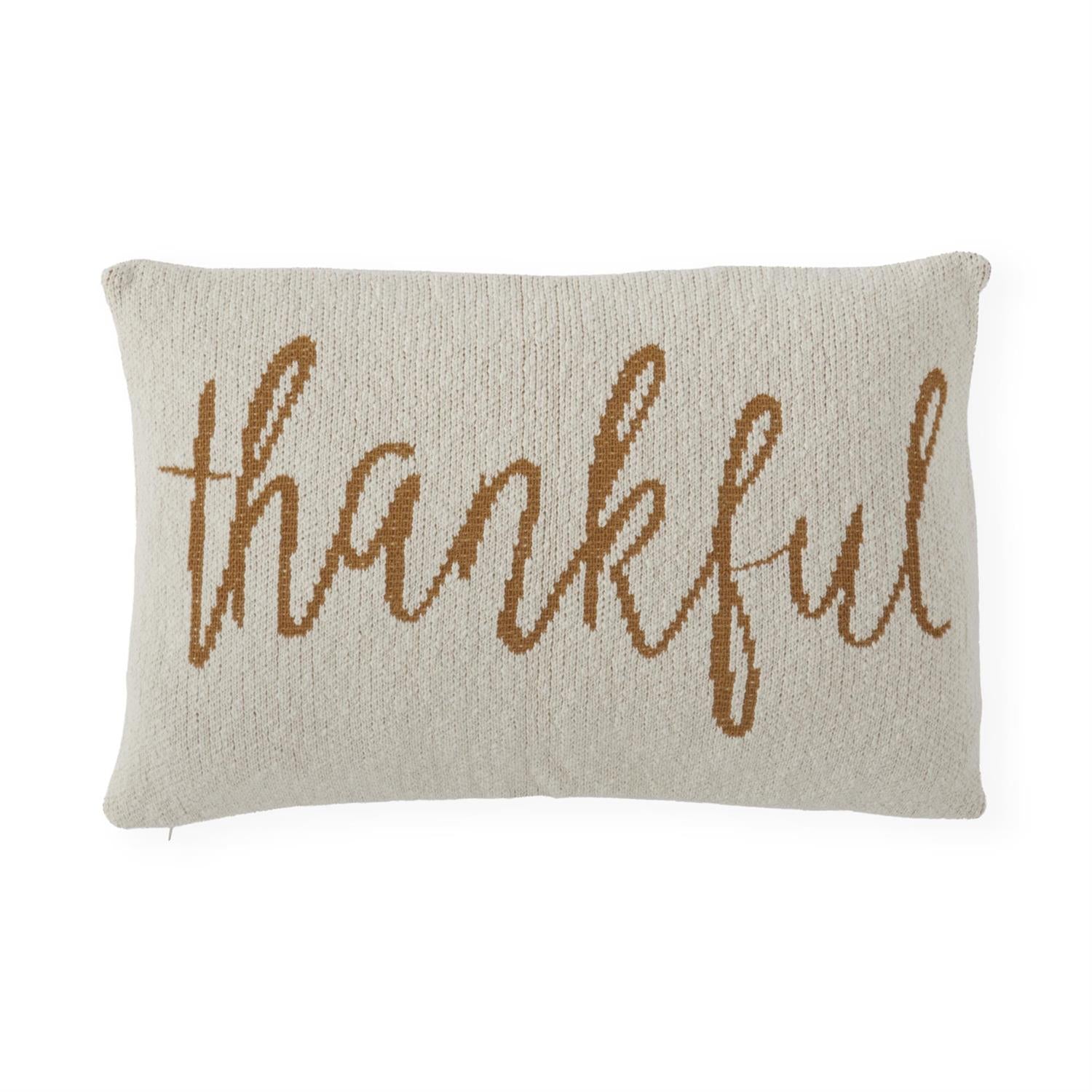 Beige knit pillow with yellow 'thankful' text on a white background