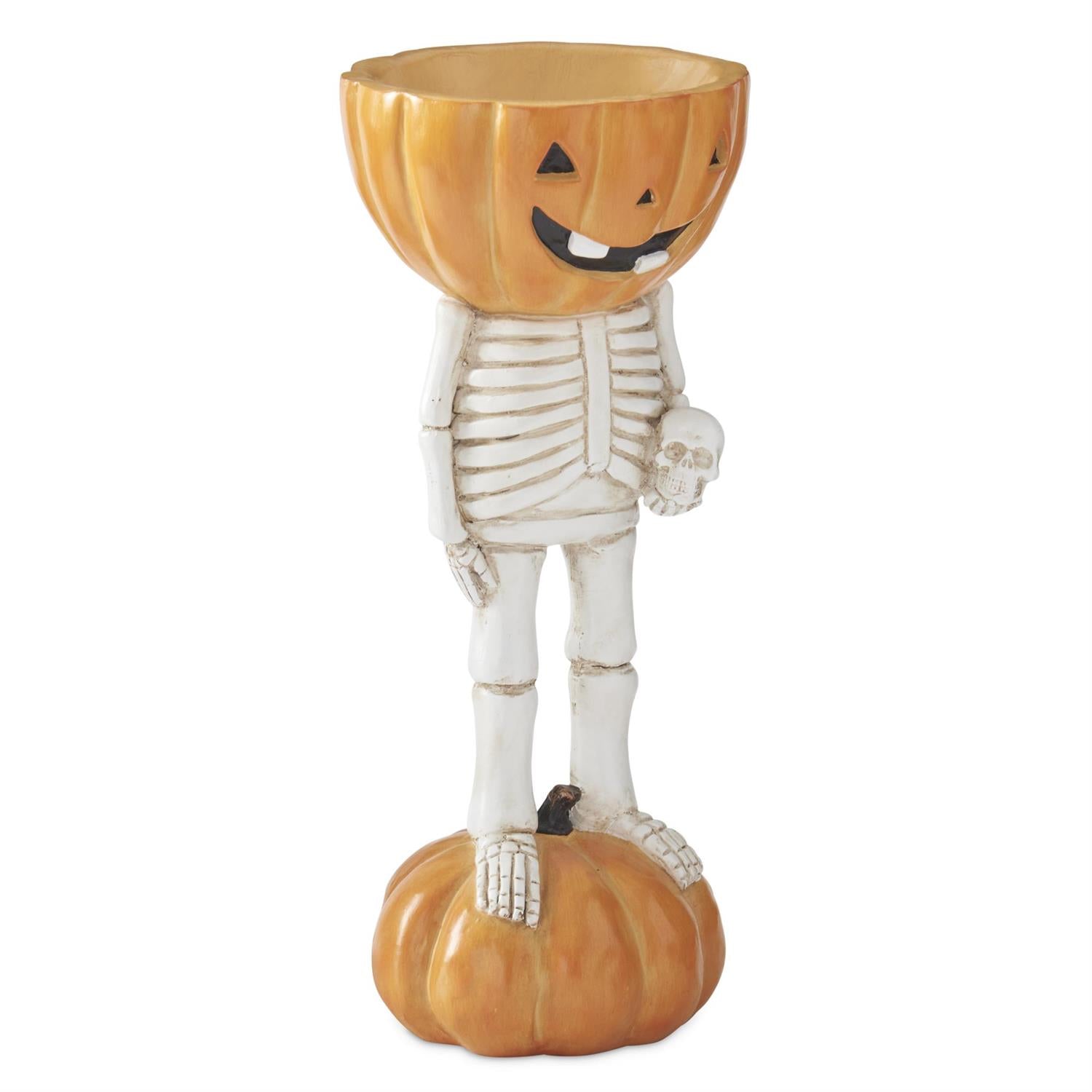 A Halloween decorative skeleton figurine standing on a pumpkin, with a carved jack-o'-lantern head and a small skull in one hand