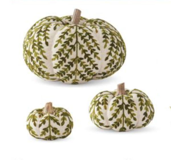 Three decorative knit cream pumpkins with a green leaf pattern and a wooden stem