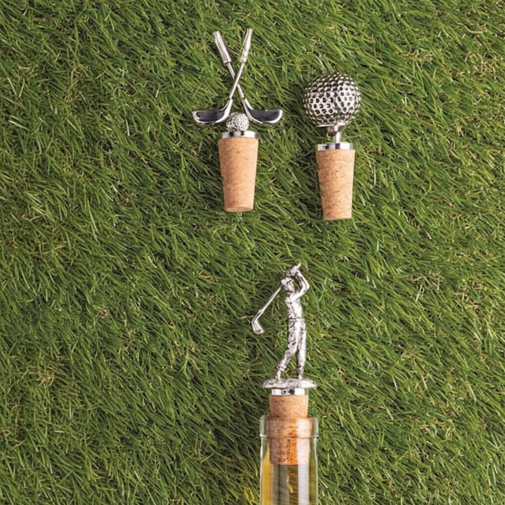 3 bottle stoppers with a pair or golf clubs, a golf ball and a golfer swing a club