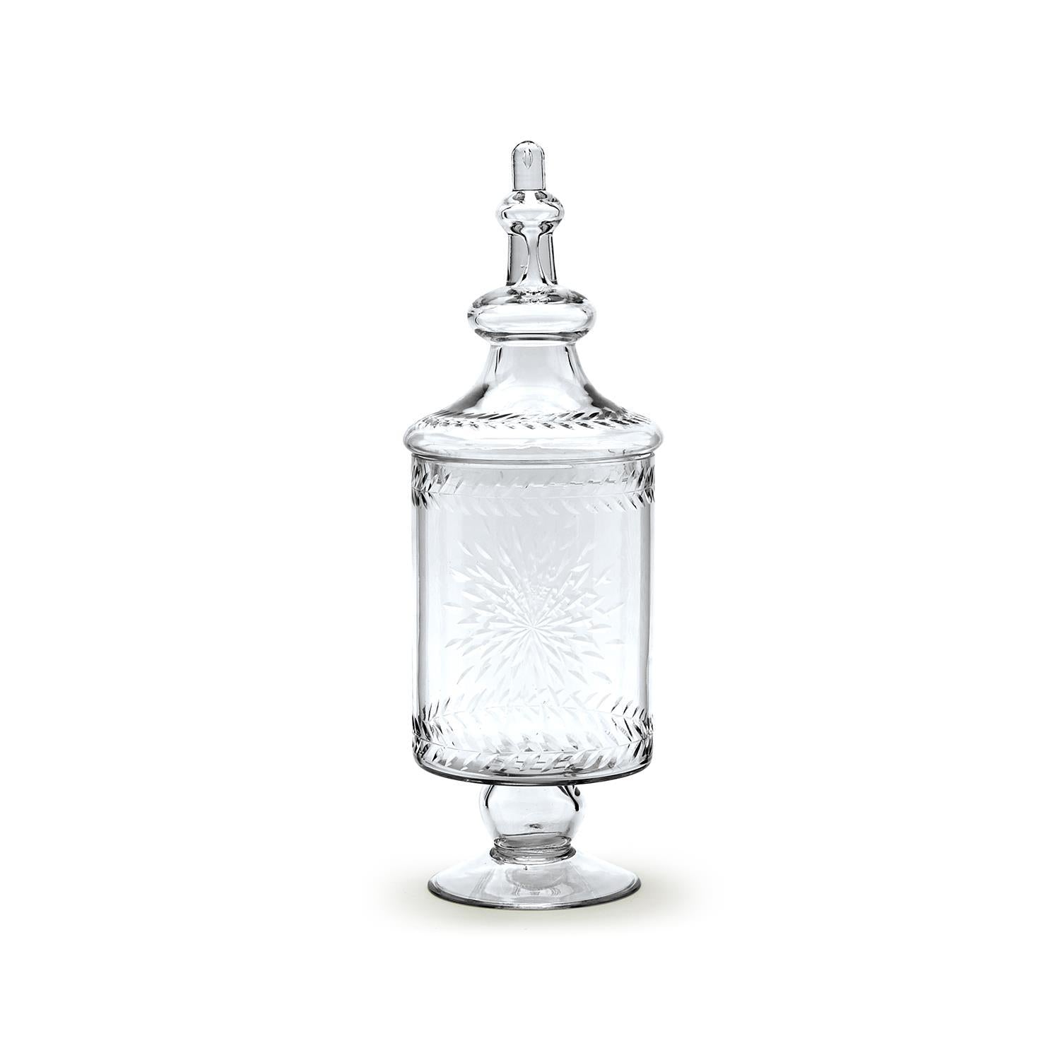 A clear glass apothecary jar with a lid, featuring etched designs and used as a decorative piece.