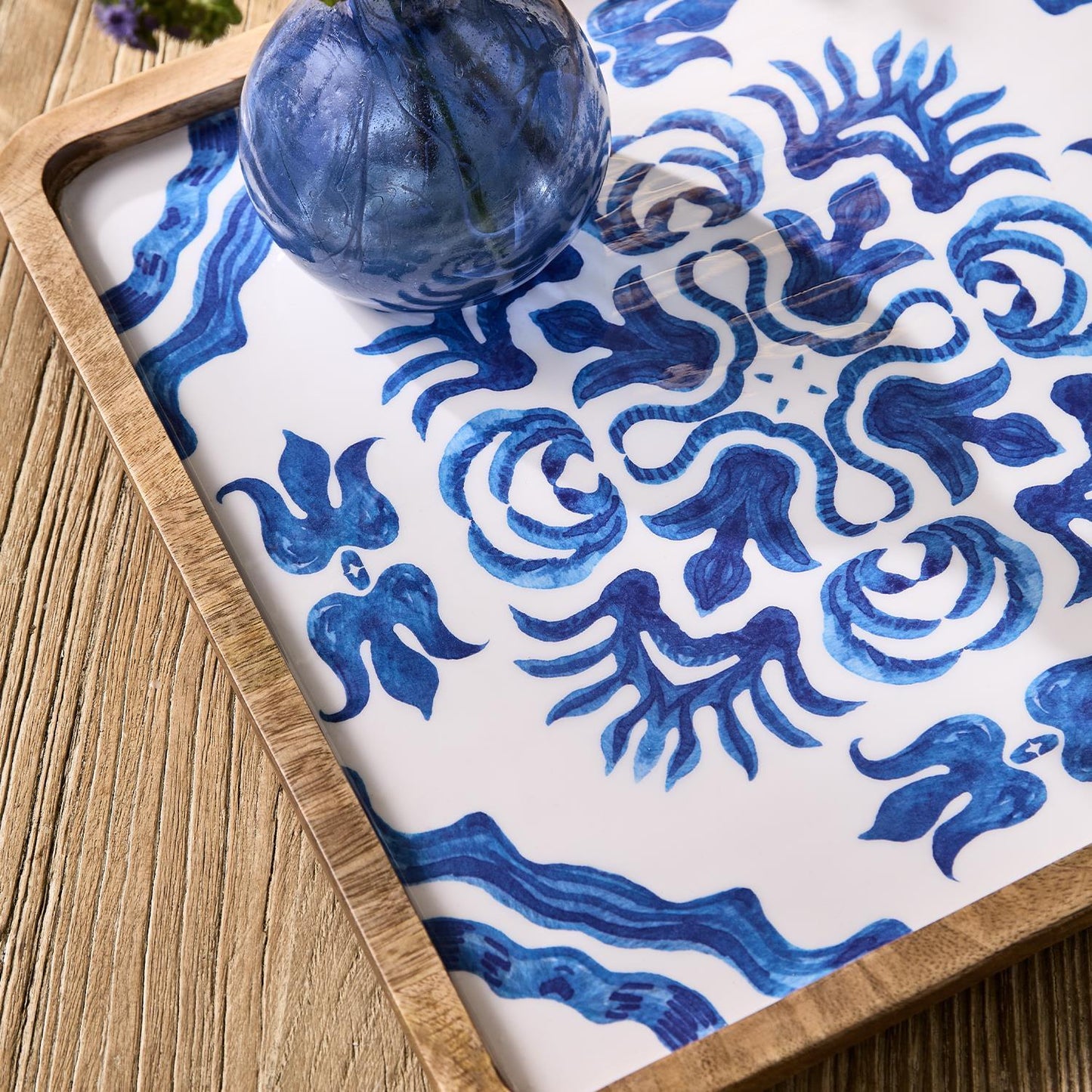 Decorative tray with blue and white pattern on a wooden surface