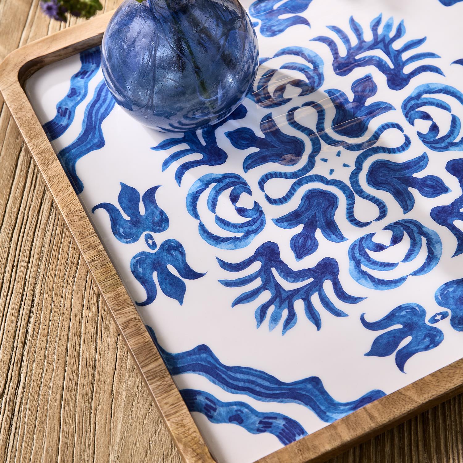 Decorative tray with blue and white pattern on a wooden surface