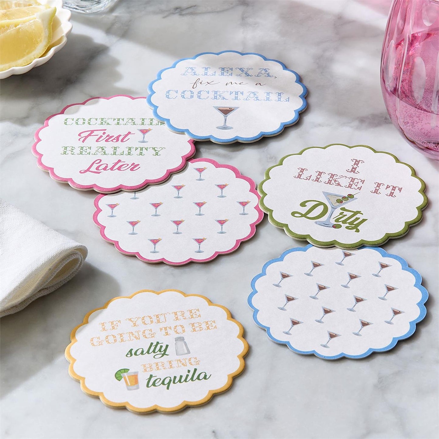 Set of six humorous cocktail-themed coasters on a marble surface.
