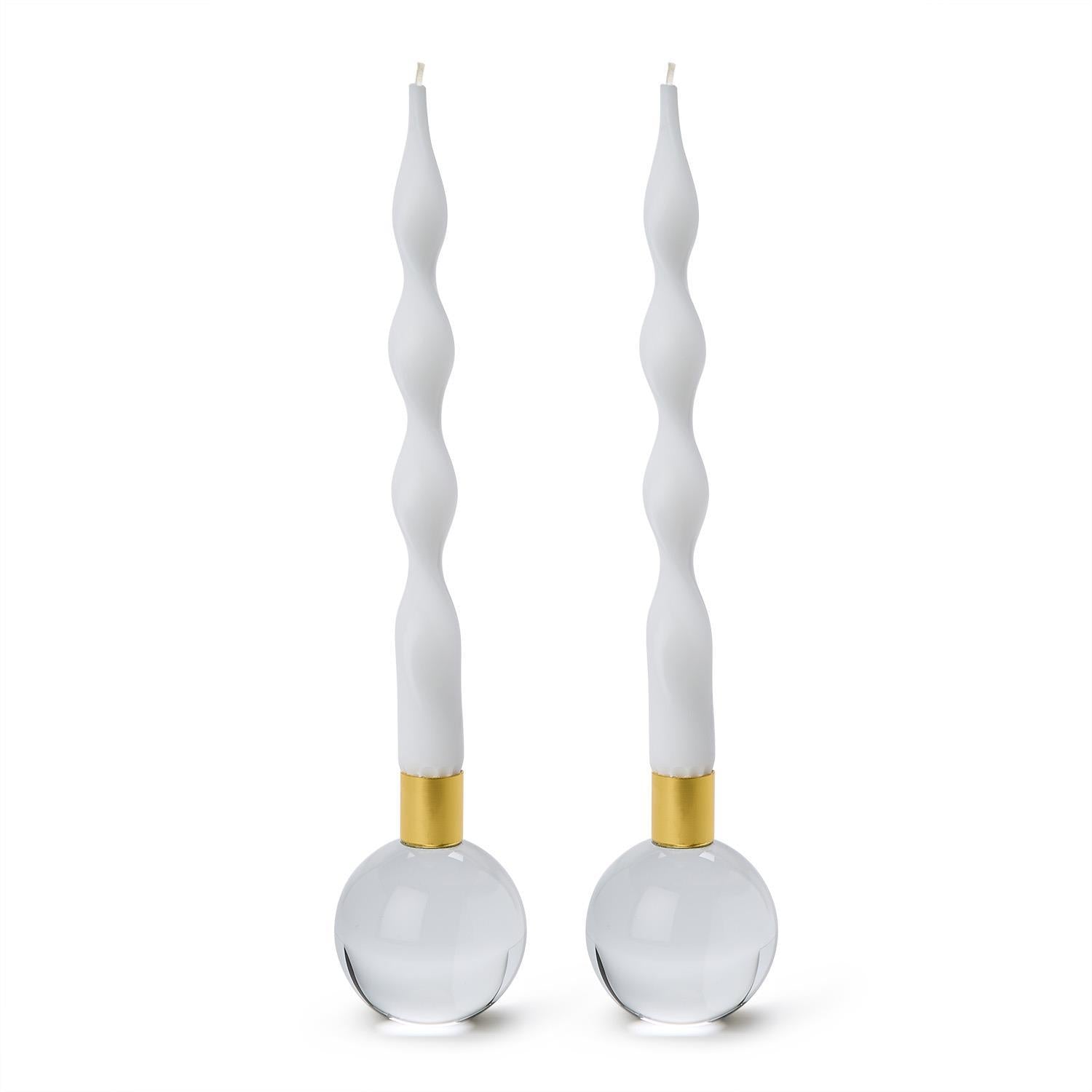 Two white spiral candles on clear candle holders with gold accents 