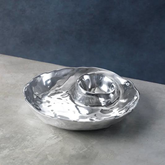 A silver metal spiral dip bowl with a textured pattern, designed after a seashell, for serving dips.