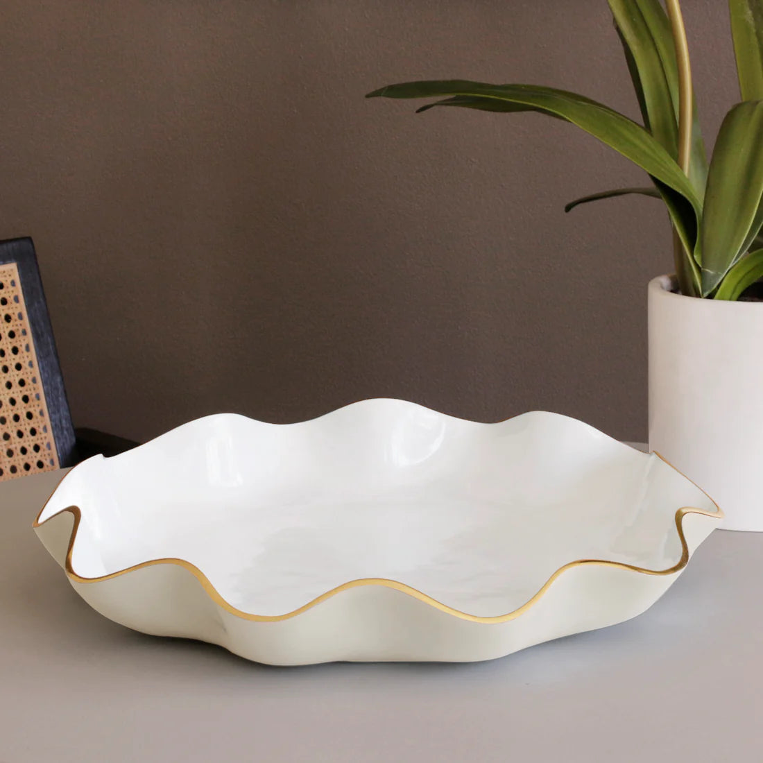 White ceramic dish with a curved gold rim