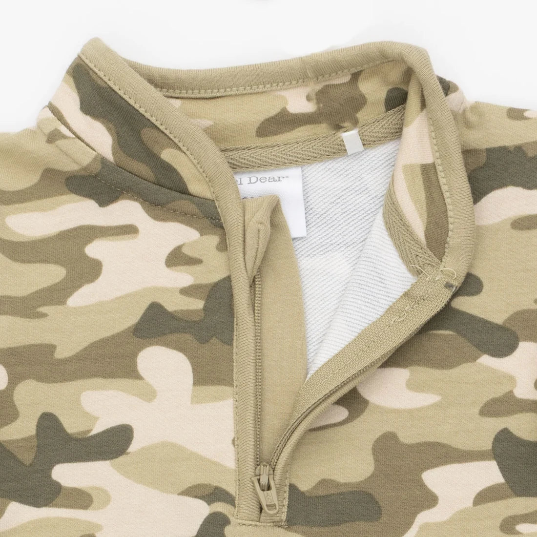 Close-up of an angel dear camouflage quarter-zip french terry romper with a tan collar and zipper, showing a white inner lining and a partially visible 'Dear' brand label.