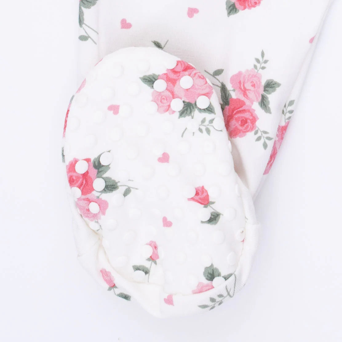 Rubber dotted foot on an Back of an Angel Dear Pink Rosettes 2 Way Ruffle Sleeve Zipper Footie with pink floral pattern on a with material