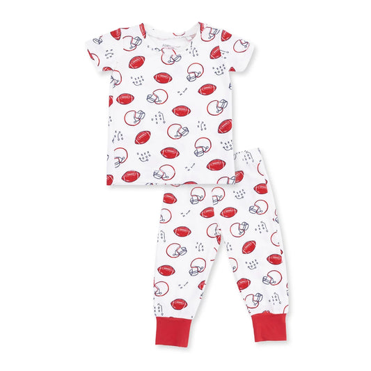 Angel dear touchdown time two-piece baby pajama set featuring a short-sleeve top and matching pants with an all-over football helmet and football print on a white background, finished with solid red cuffs.