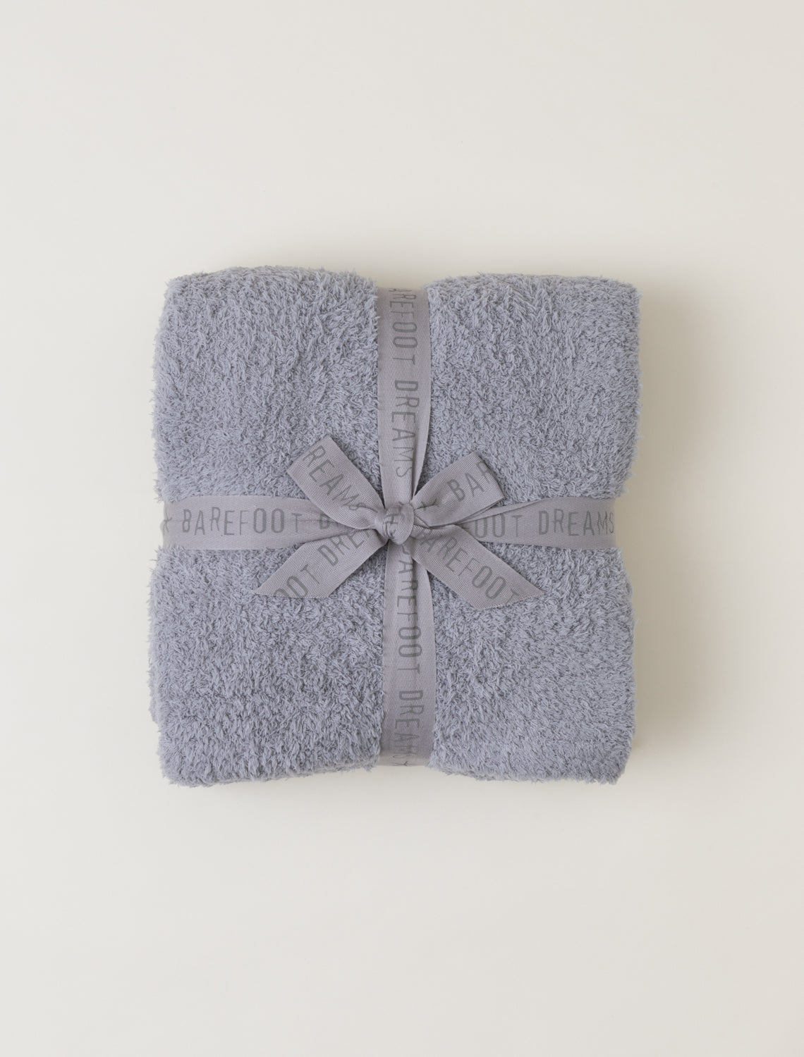 Barefoot dreams cozychic throw in dove gray folded with a matching ribbon