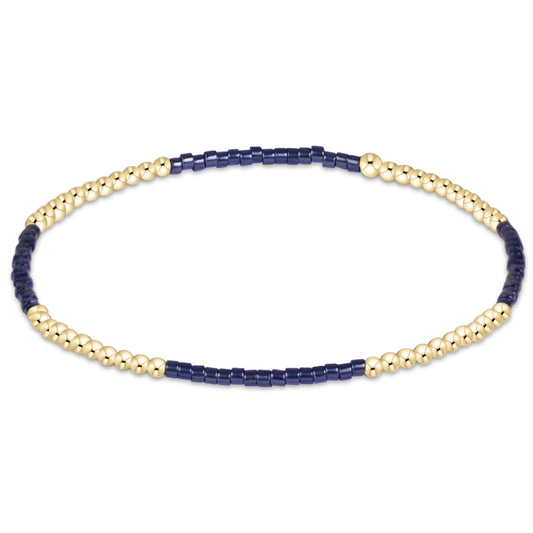 A delicate beaded enewton Hope Blissful Navy and gold bracelet featuring alternating sections of polished gold-toned round beads and dark navy blue cylindrical beads, displayed on a clean white background.