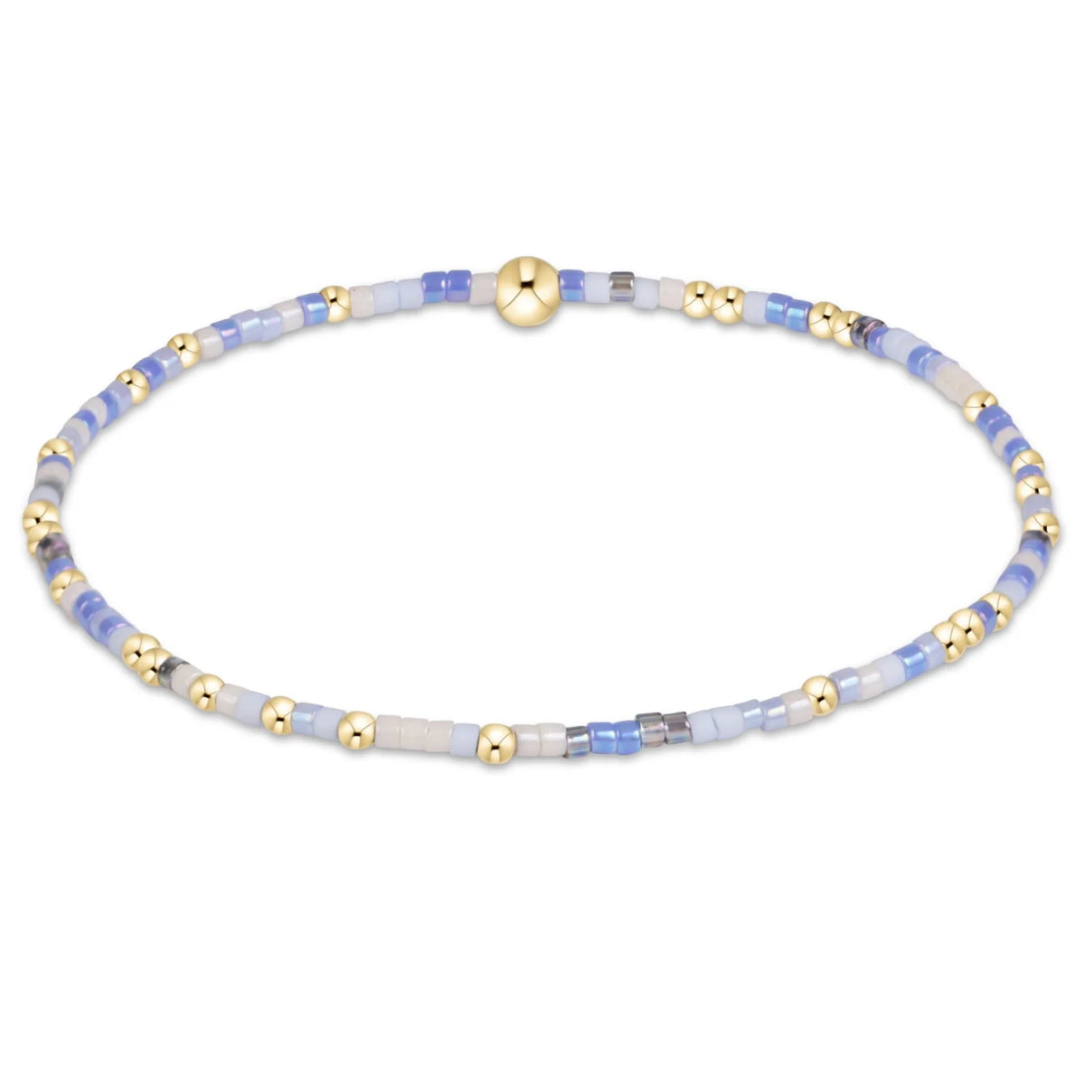 A delicate beaded enewton hope unwritten bloopers bracelet with white and  light blue and white translucent beads, accented by shiny gold metallic beads and a central gold clasp, shown on a plain white background.