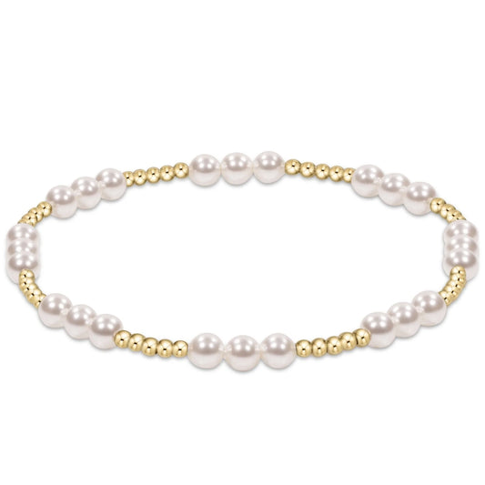 An enewton joy pearl 4mm stretch bracelet featuring white freshwater pearls and small polished gold spacer beads, arranged in an oval shape on a clean white background.