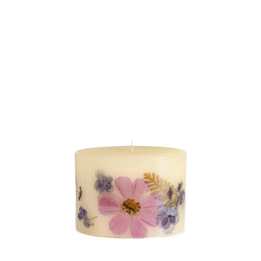 cream oval candle with pressed flowers in shades of purple