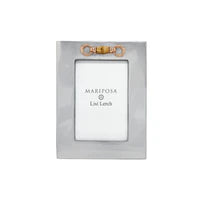 A silver-toned rectangular picture frame with a small gold bow at the top and a white insert card reading 'MARTHA STONE & LISA LAMB'.