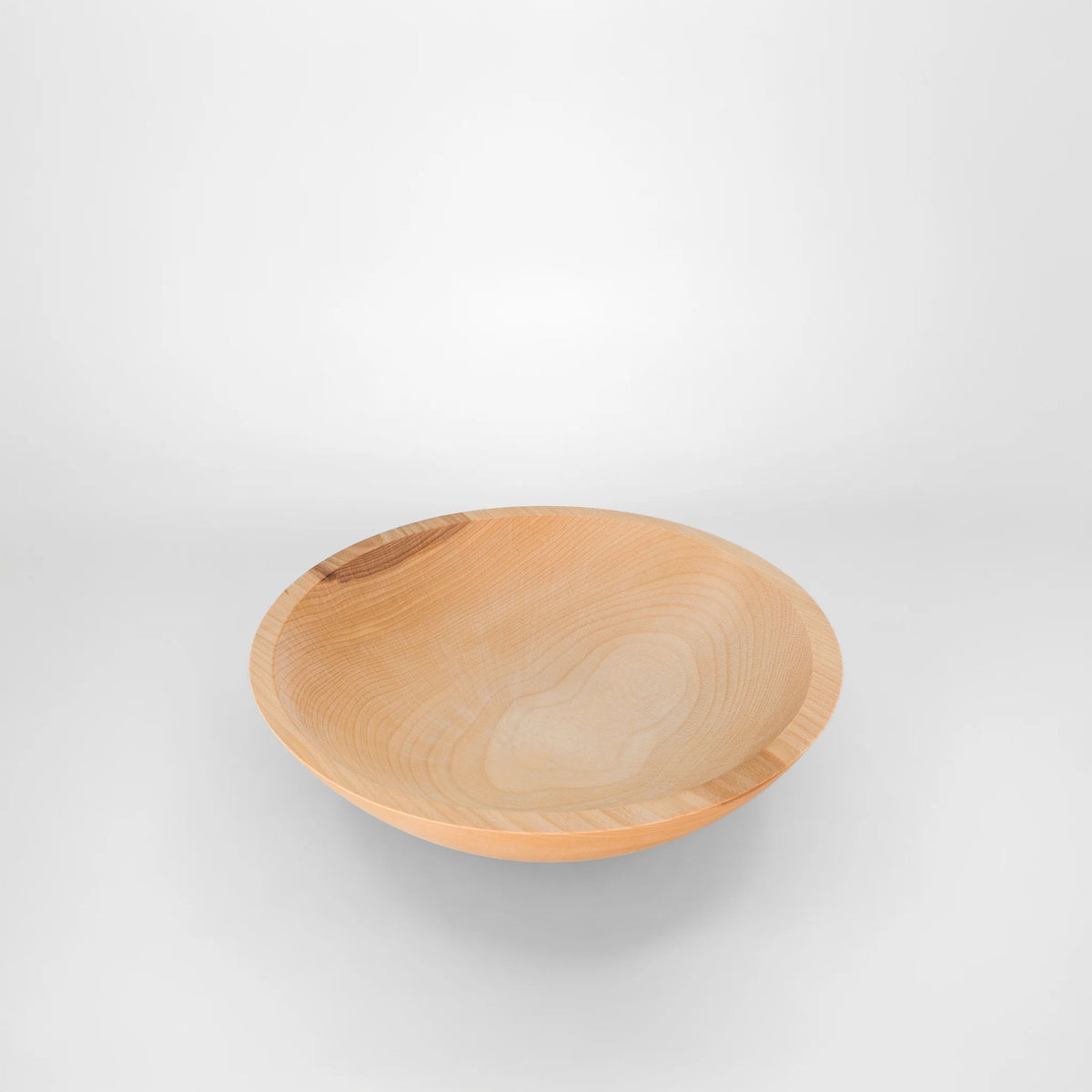 A round 12" wooden salad bowl with a light natural maple wood grain finish, by holland bowl mill shown from a high angle on a light gray background.