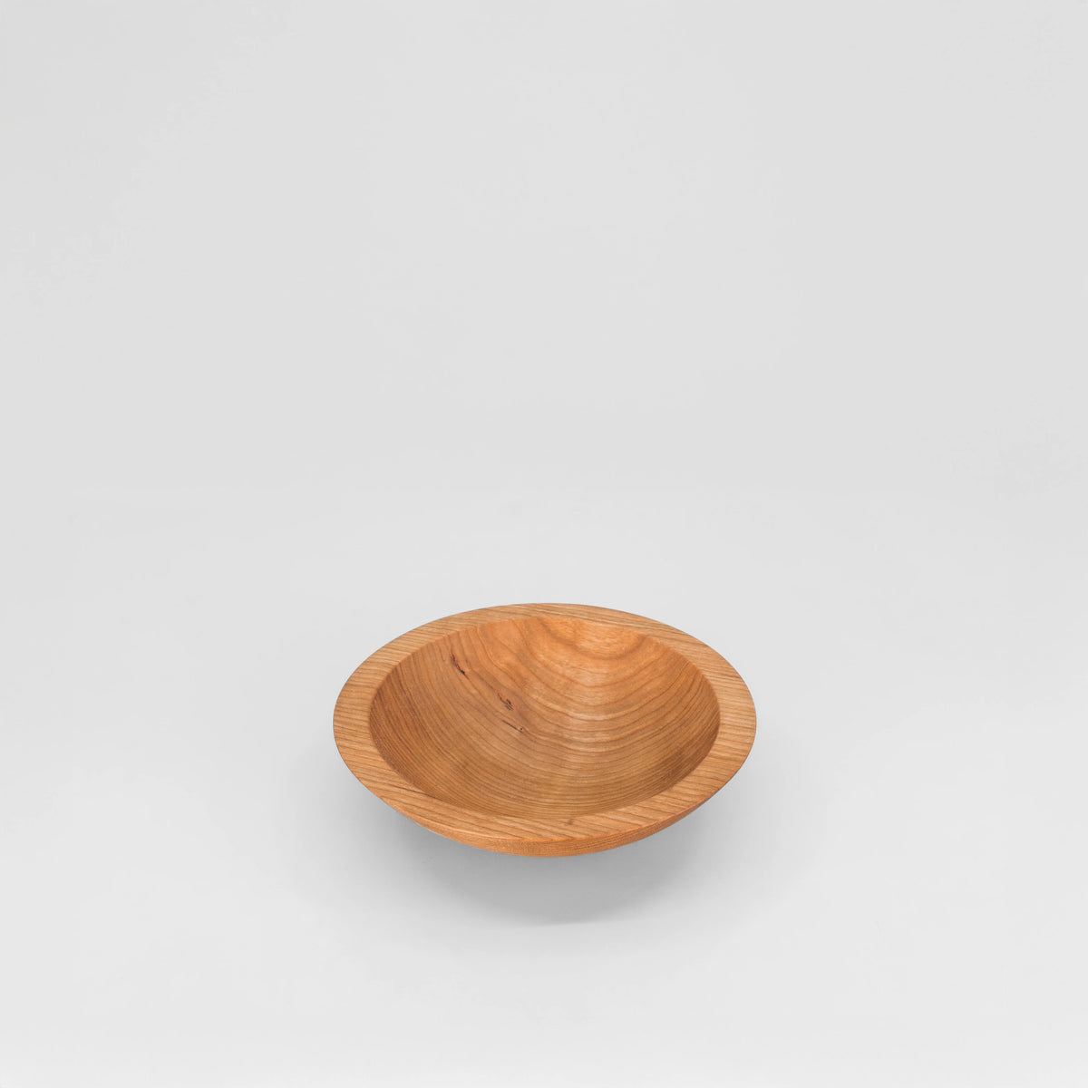 A small 6" cherryround wooden bowl with a smooth, polished finish and visible wood grain, engraved with trees and doves centered against a solid light gray background.