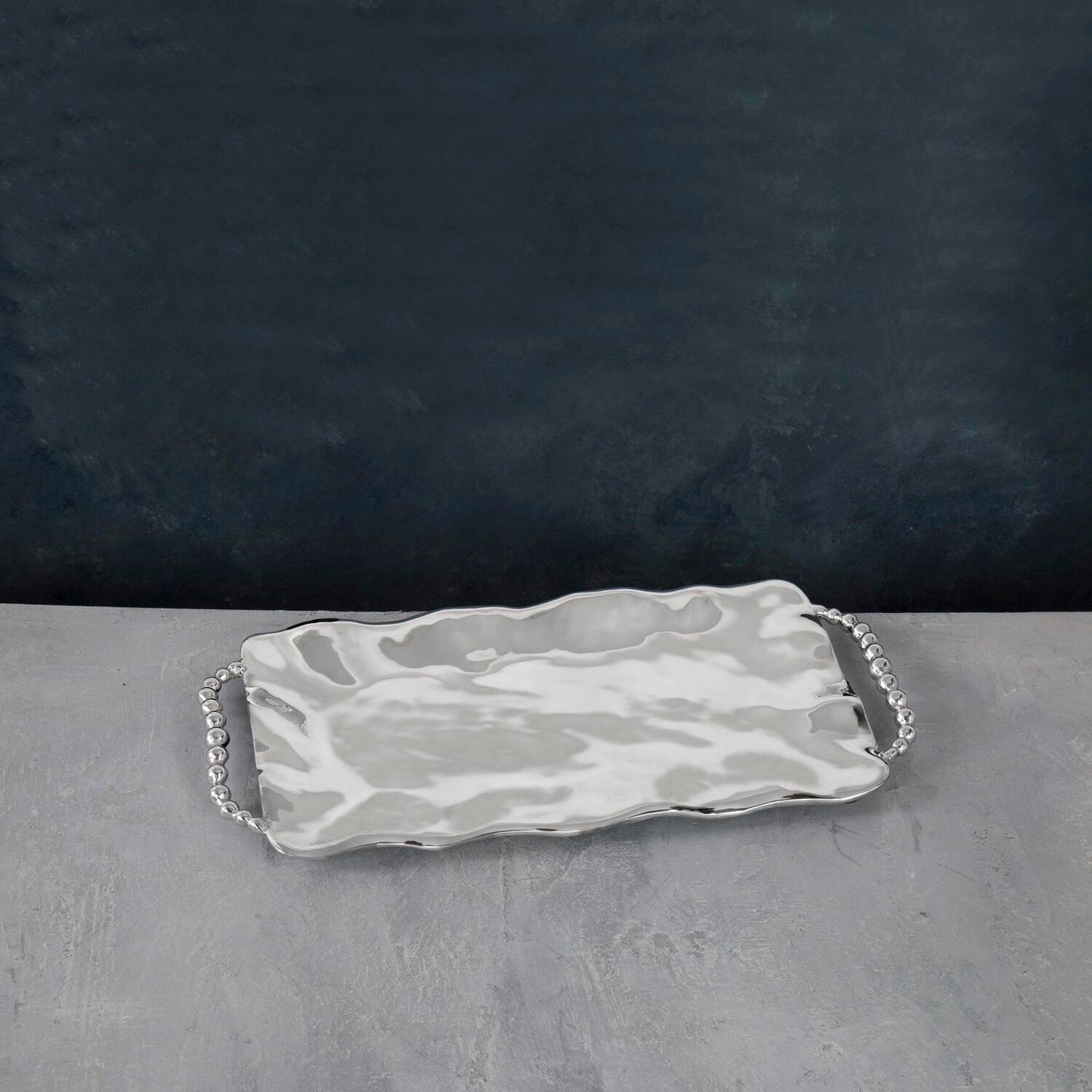A rectangular serving tray with handles, featuring a pearl-like patterned design.