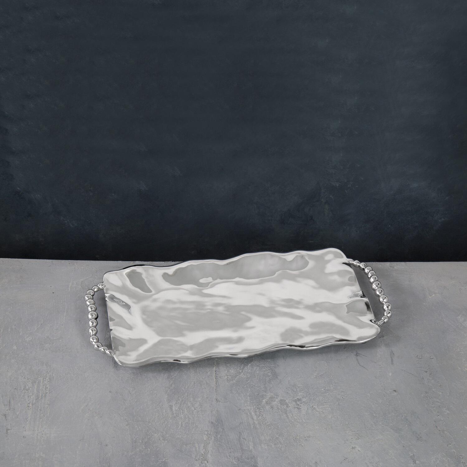 A rectangular serving tray with handles, featuring a pearl-like patterned design.