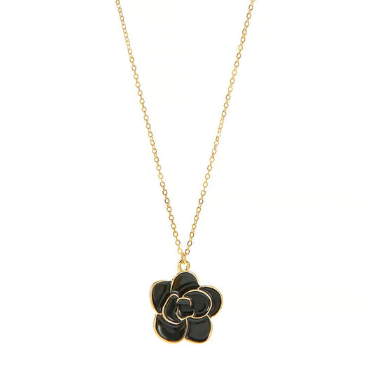 Charlie Paige Black Rose Bloom Gold Necklace Black flower pendant on a gold chain against a white background