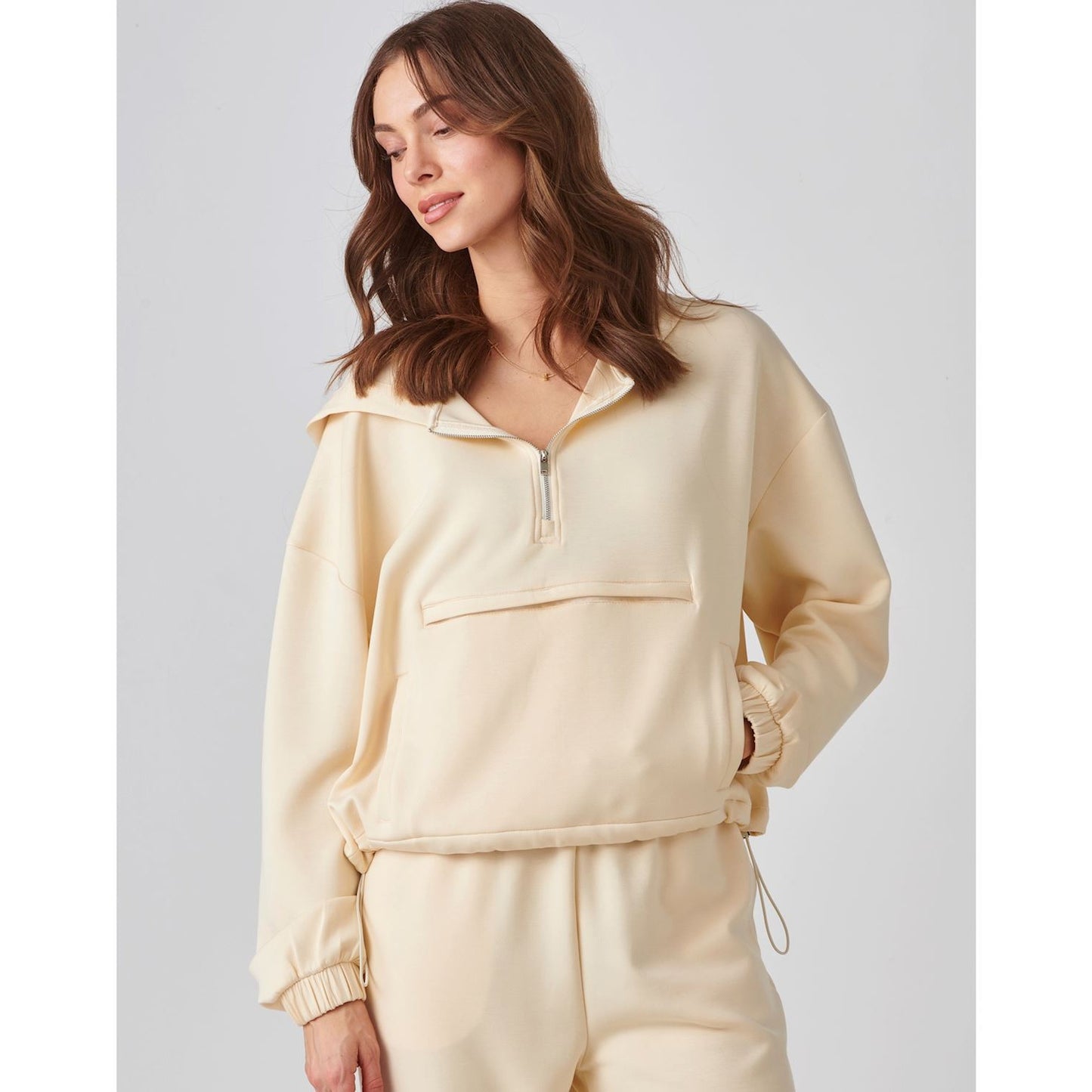 Woman wearing a Charlie Paige Zip Neck Hoodie Pullover, Off Whiteagainst a plain background