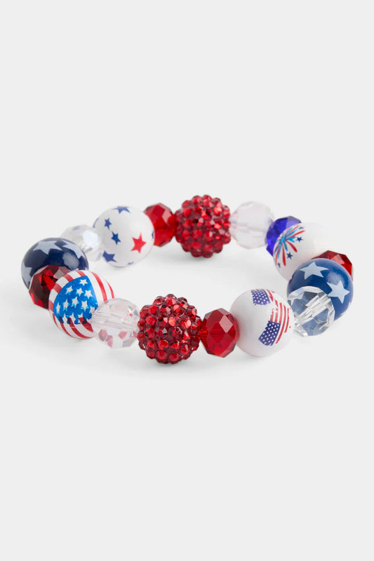 Coco + Carmen Whispers USA Fireworks stretch Bracelet with American flag beads on a white background