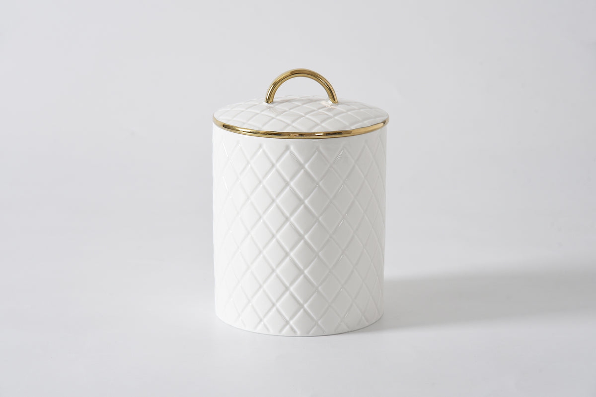 White ceramic canister with a diamond pattern and a gold rim and handle on the rim