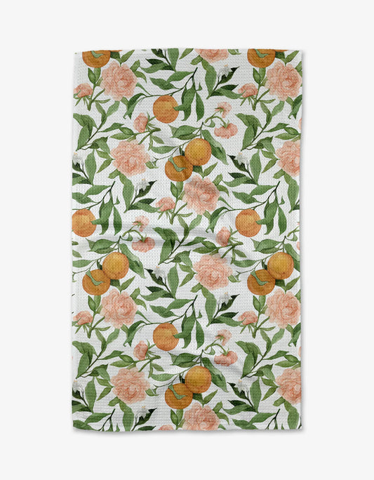 Geometry tea towel in A peony for your thoughts print featuring pink peony, oranges, white flowers and green leaves on a white towel.
