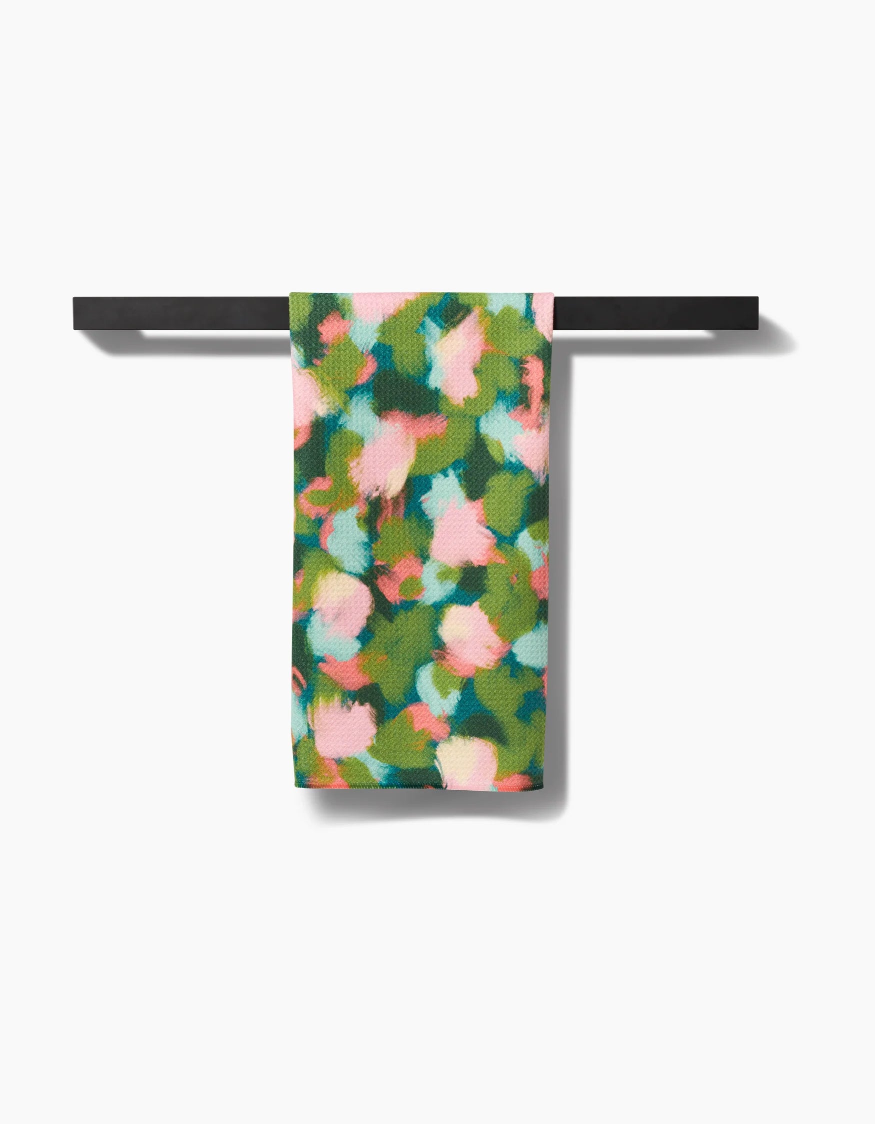 Stroke of Genius printed Geometry tea towel hanging on a black rod against a white background