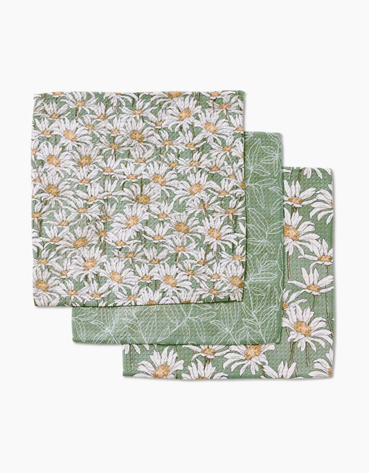 Close up of the 3 patterns in the Springtime dishcloth set.  All patterns are sage green , two have white and yellow daisy flowers and the other has a white line botanical design.